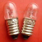 Close-up of two E10 screw instrument bulbs with metal bases on red background