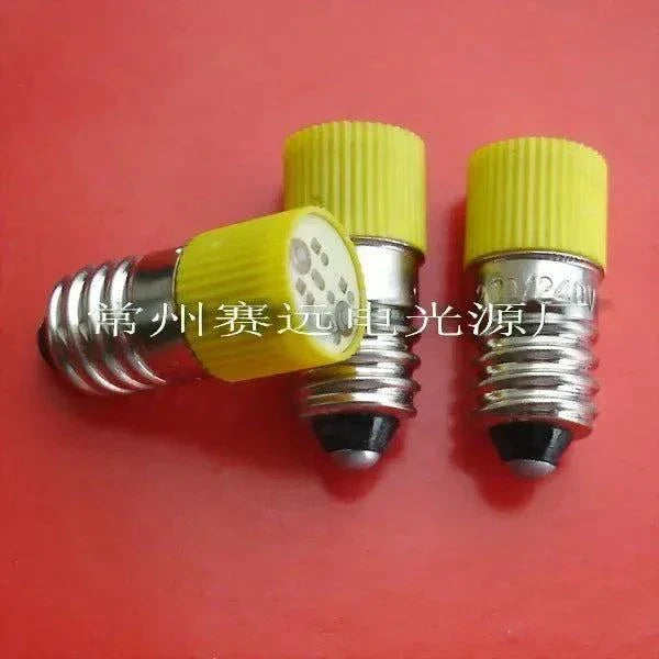 Set of three LED bulbs 220v/240v with E10 base and yellow ribbed caps on red background
