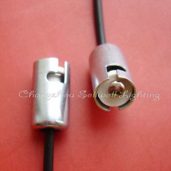 Close-up of silver lamp holders Ba9s with attached black wires on red background