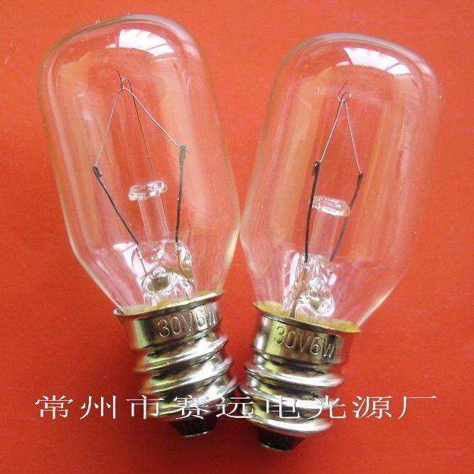 Close-up of two E12 instrument bulbs with 30V 6W markings against an orange background