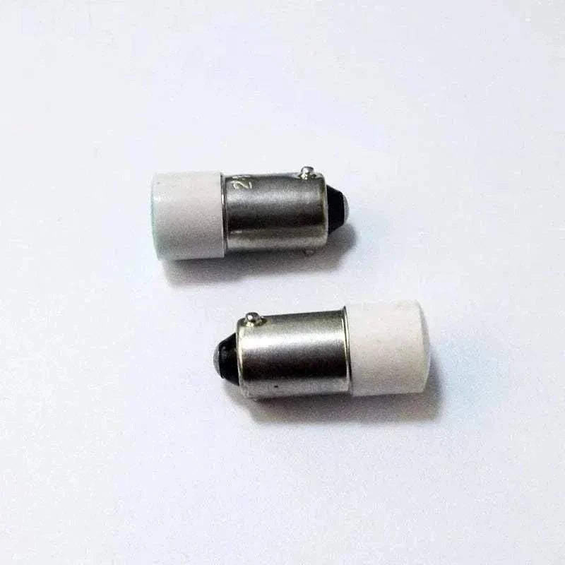 Two BA9S LED indicator bulbs with bayonet base and white caps on a white background