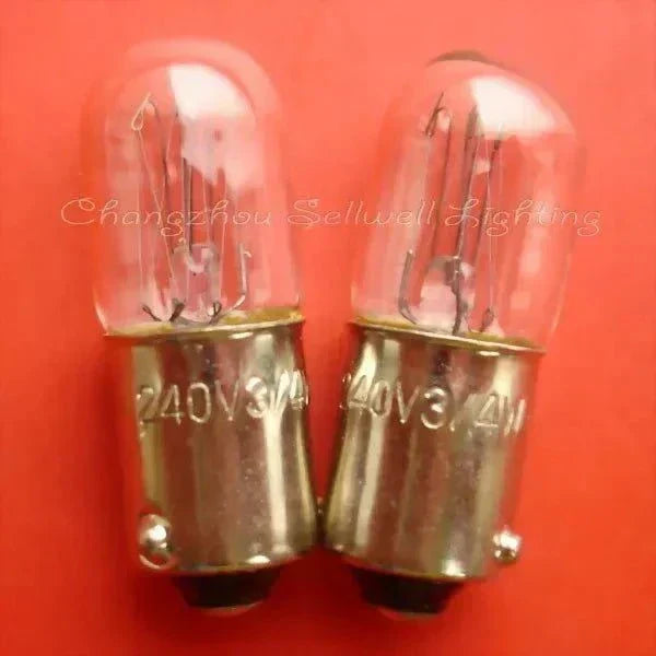 Two 240V 3/4W BA9S miniature lamps with glass bulbs on red background